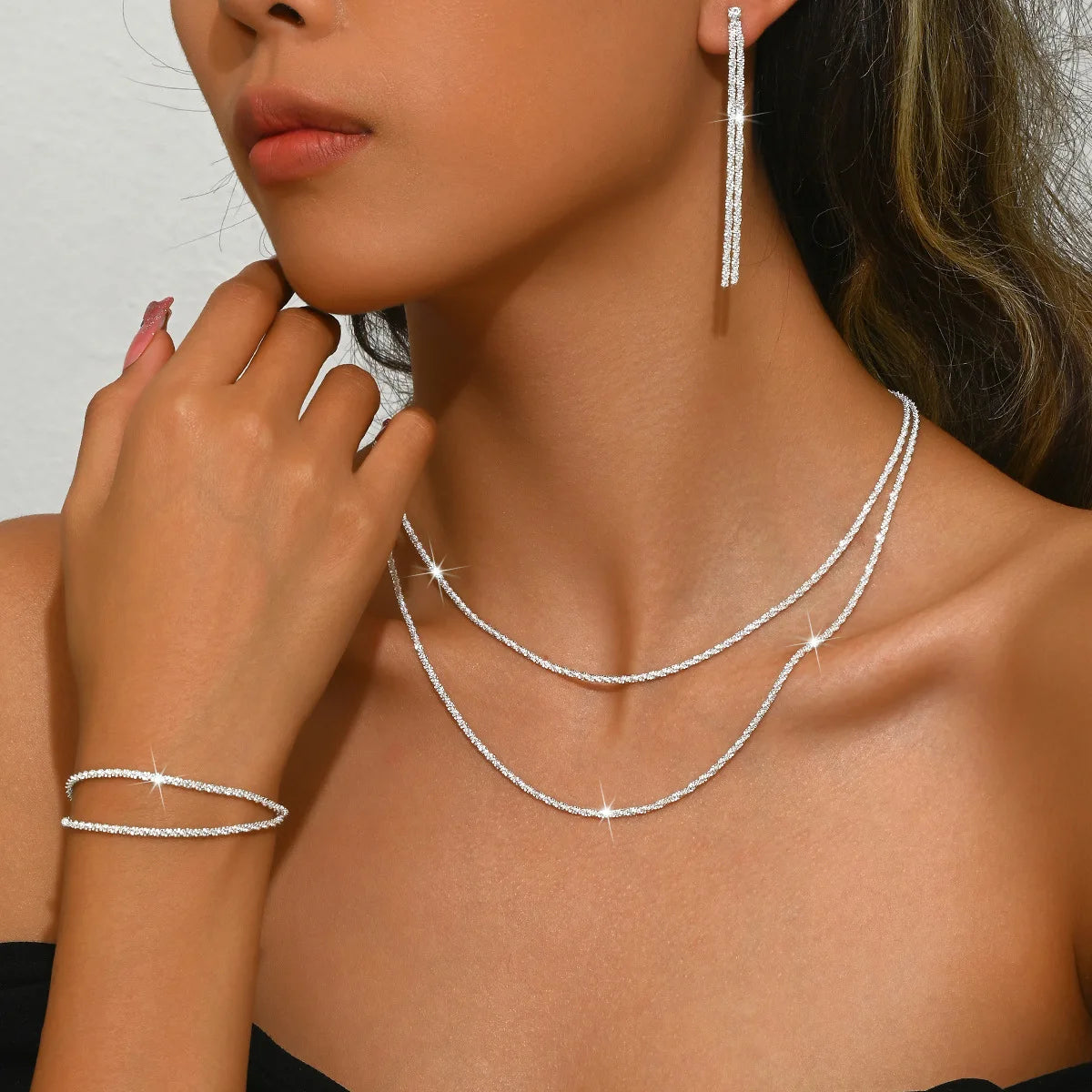 Sæt med sølvbelagte kravebenskæder og armbånd i moderne smykkedesign