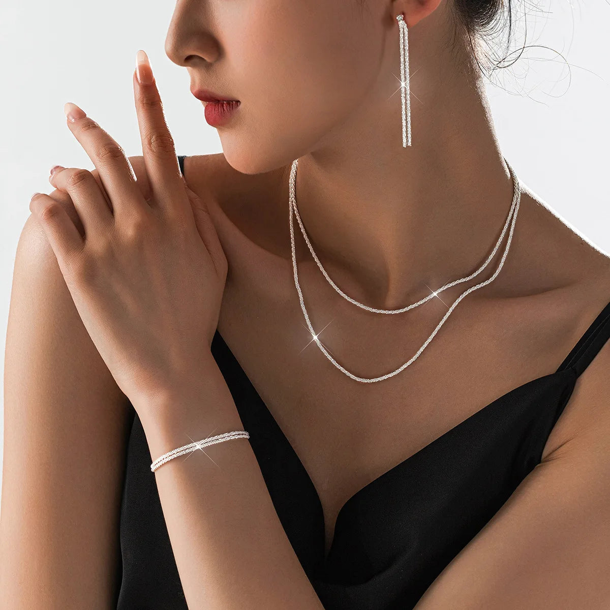 Sæt med sølvbelagte kravebenskæder og armbånd i moderne smykkedesign
