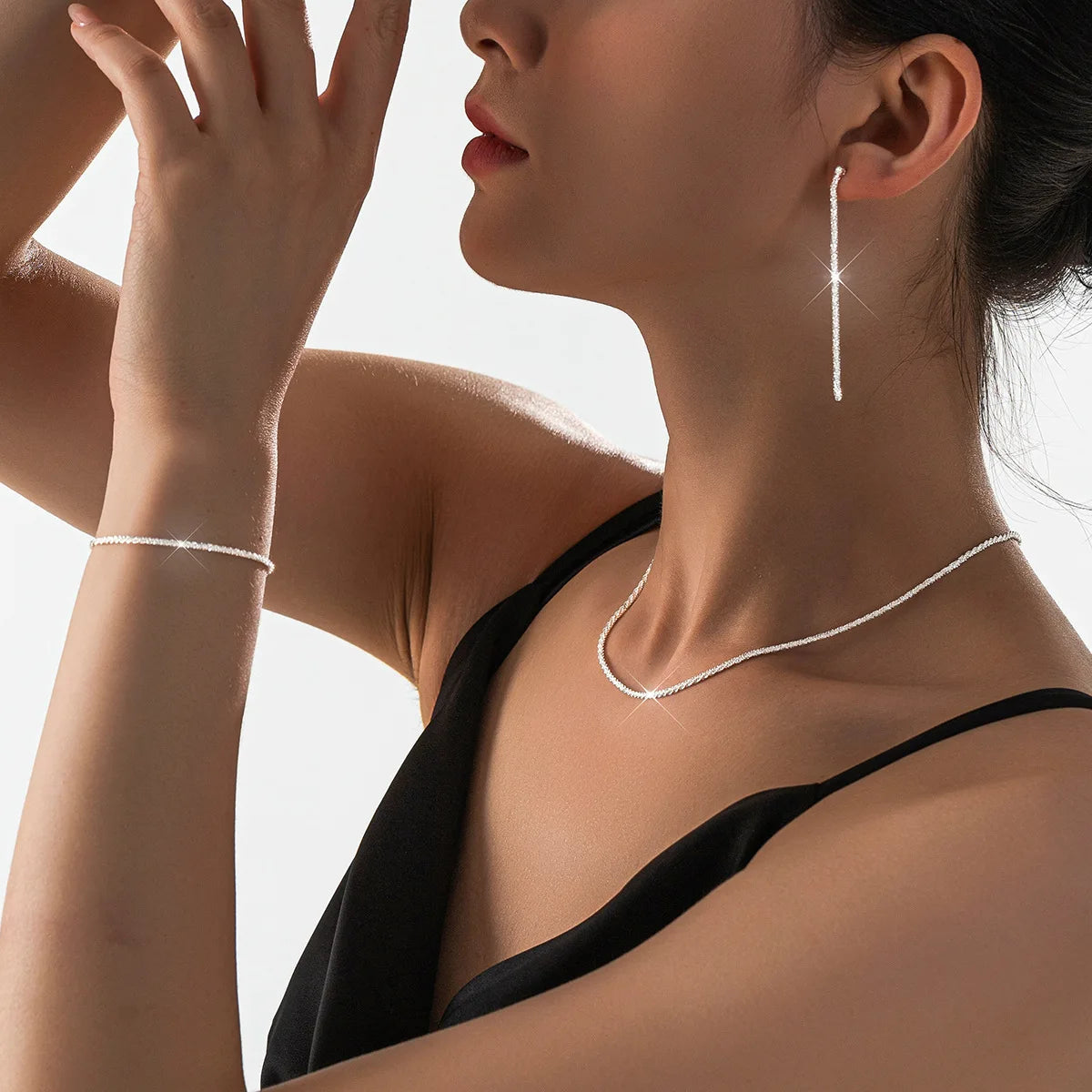 Sæt med sølvbelagte kravebenskæder og armbånd i moderne smykkedesign
